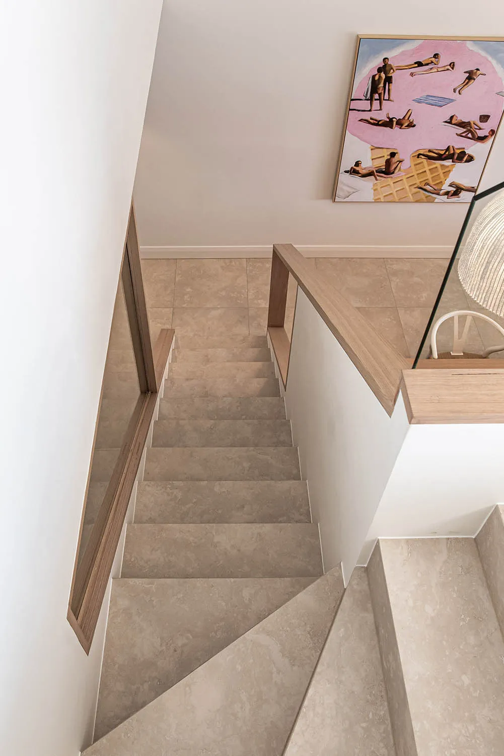 Tiled staircase with a timber handrail and glass balustrade
