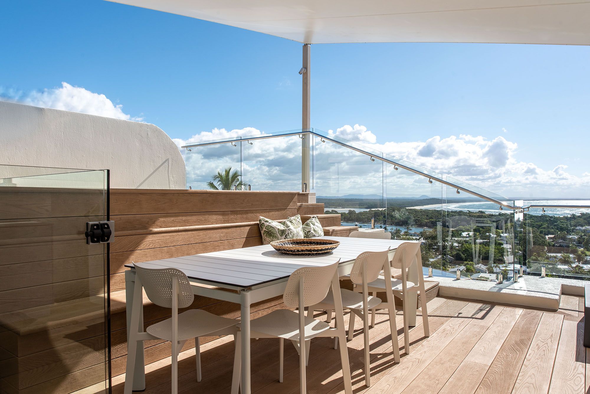 Rooftop terrace with timber decking, glass balustrade and outdoor dining overlooking the Sunshine Coast