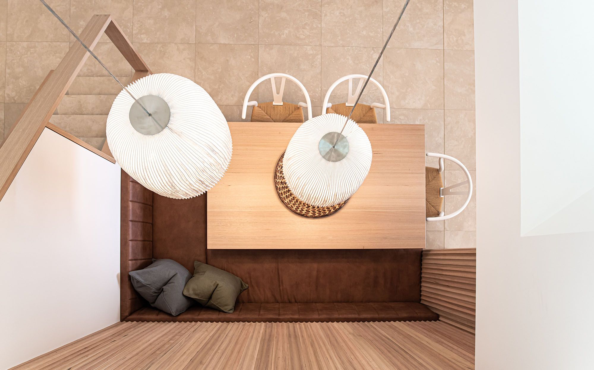Built-in timber dining nook with woven pendant lights, seen from above